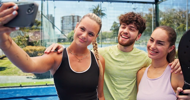 Three ACE members smiling on an outdoor sports court